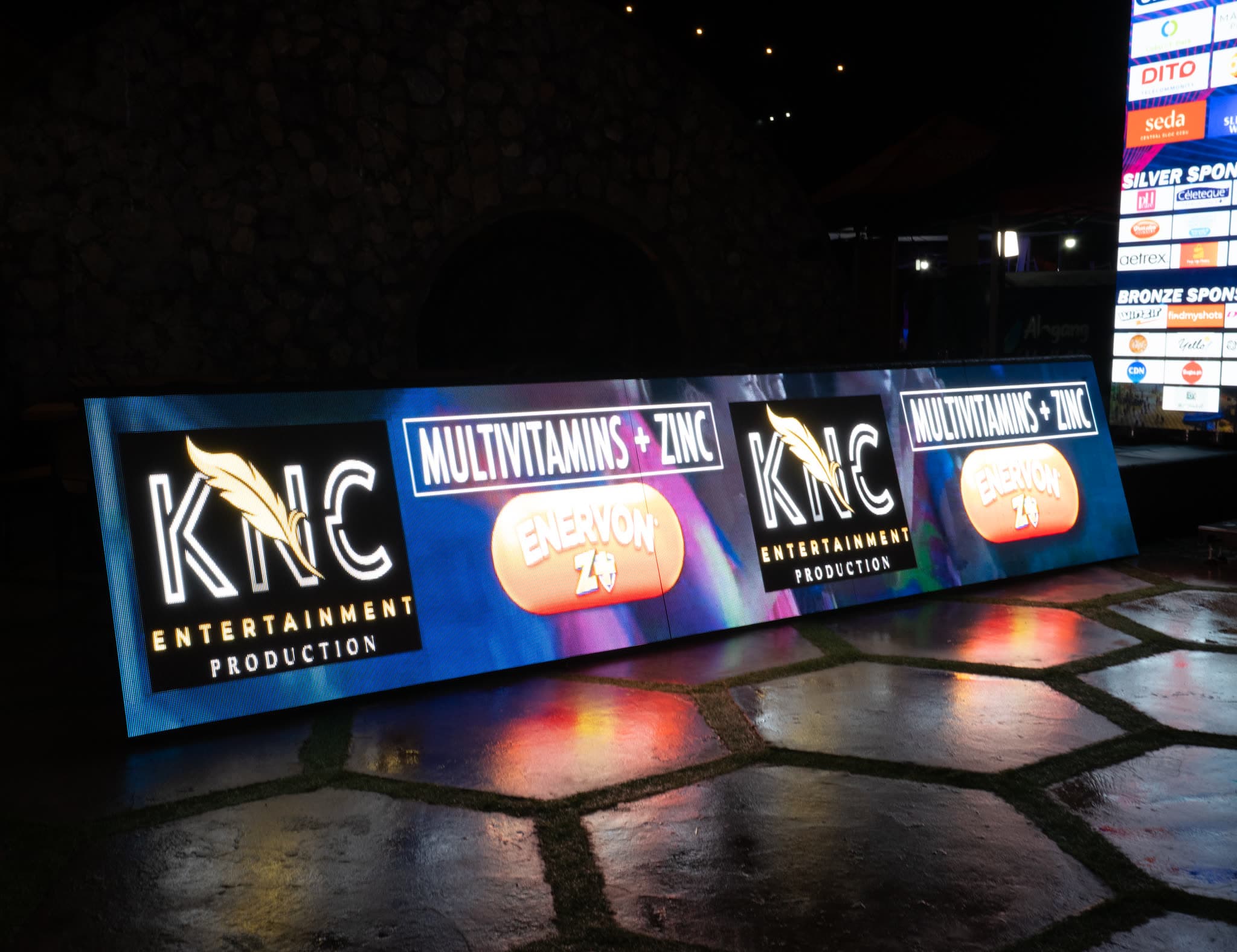 Outdoor LED banner wall at night running sponsor content for an event